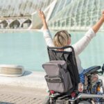 vista-posterior-mujer-silla-ruedas-brazos-abiertos-disfrutando-concepto-vida-libertad_704508-189